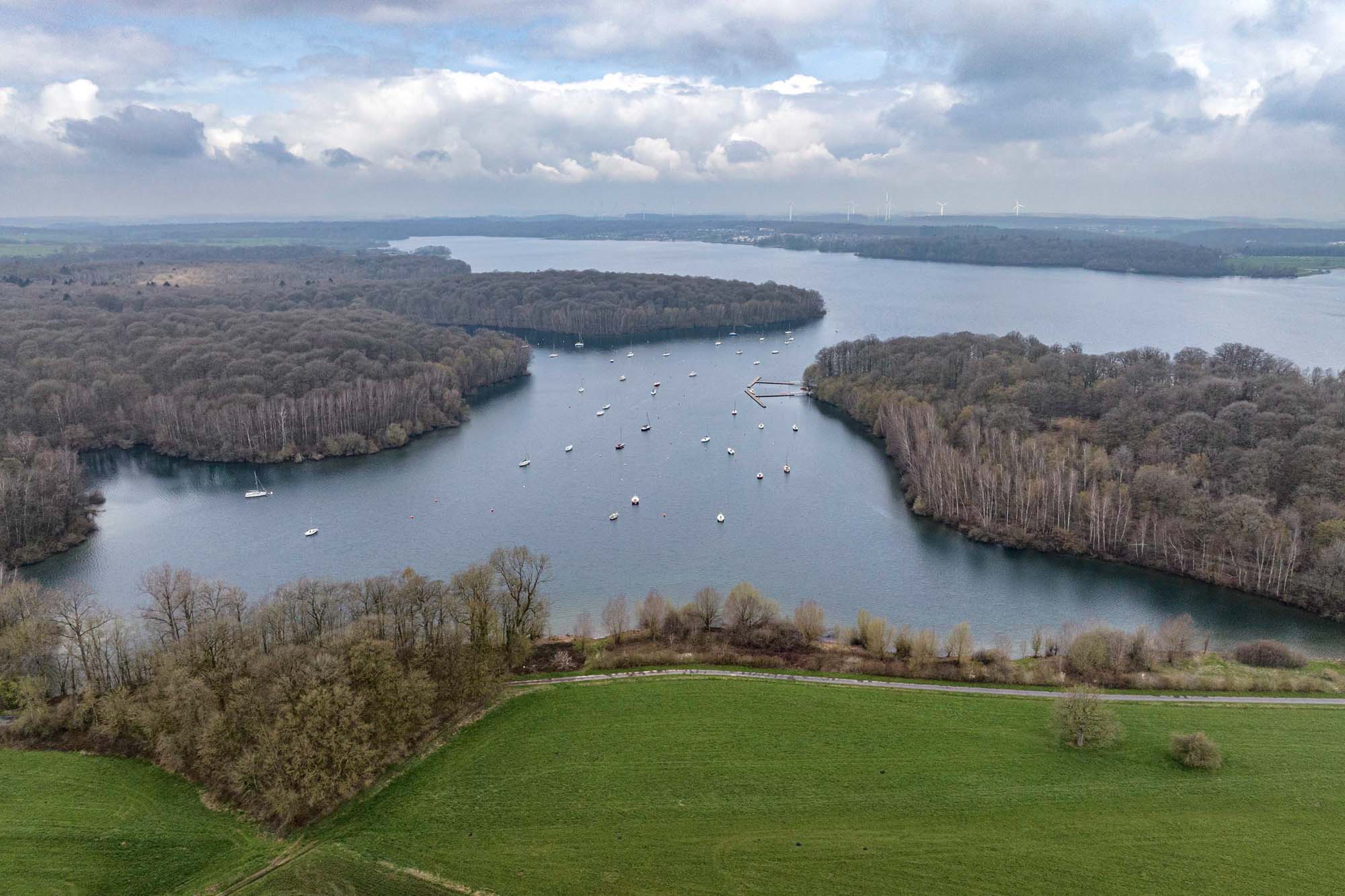 Luchtfoto van de Lacs de l’Eau d’Heure met zeilboten, omliggende bossen en beboste oevers.