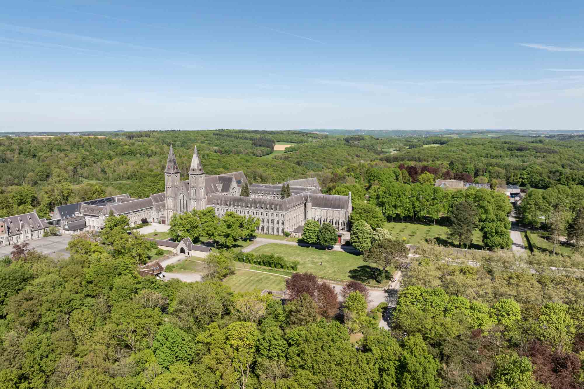 Abdij van Maredsous vanuit de lucht omringd door bossen en groene weilanden