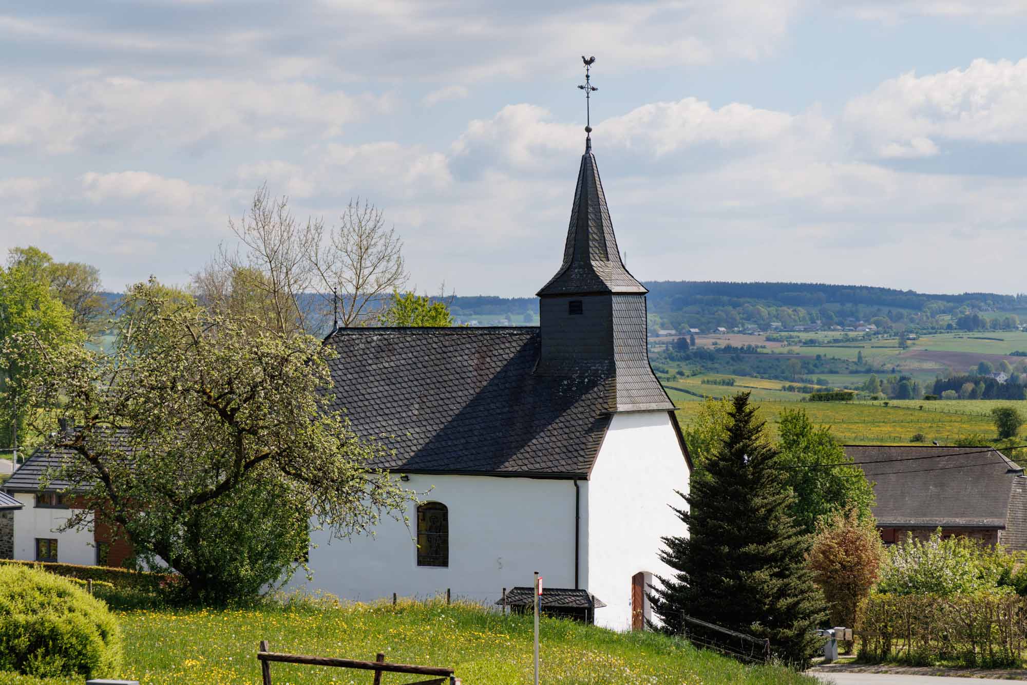 Kapel van Eibertingen tussen de weiden in het glooiende landschap van Amel