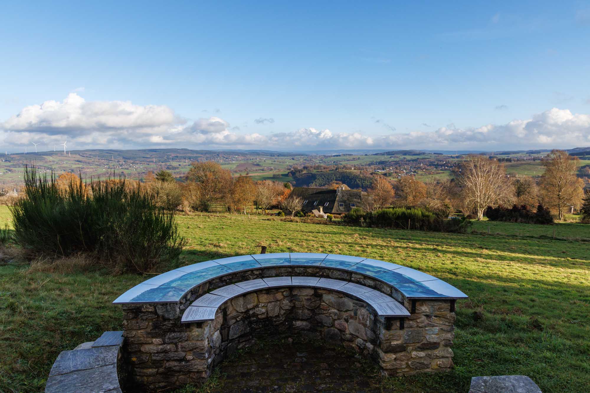 Oriëntatietafel van Baneux met uitzicht op heuvels en valleien onder een heldere hemel.