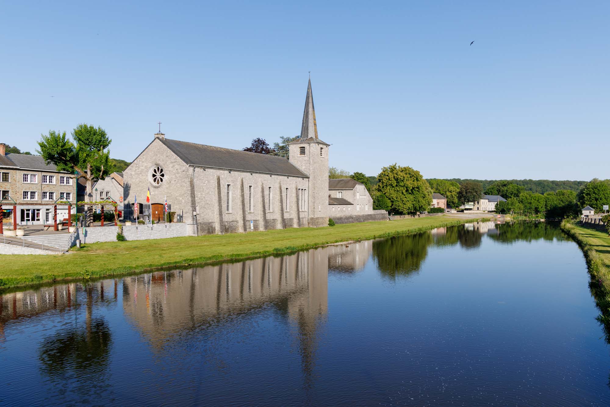 De kerk Notre-Dame Consolatrice aan de oevers van de Ourthe in Hotton