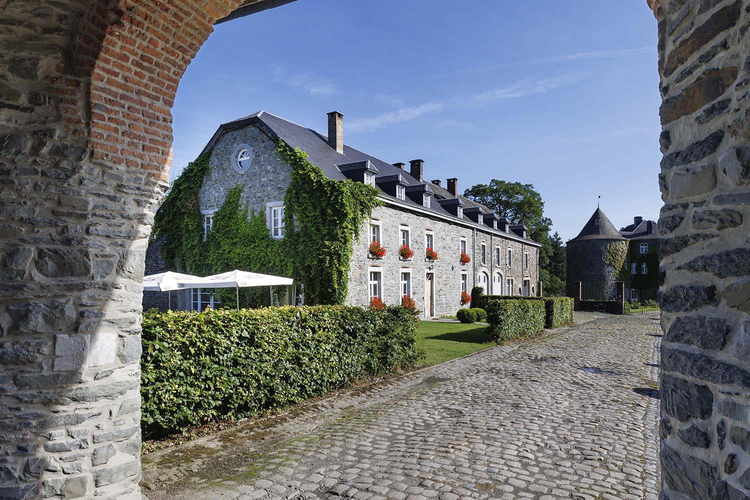 Gevel van een karaktervol vakantiehuis in Bertogne, gezien vanaf een geplaveid pad