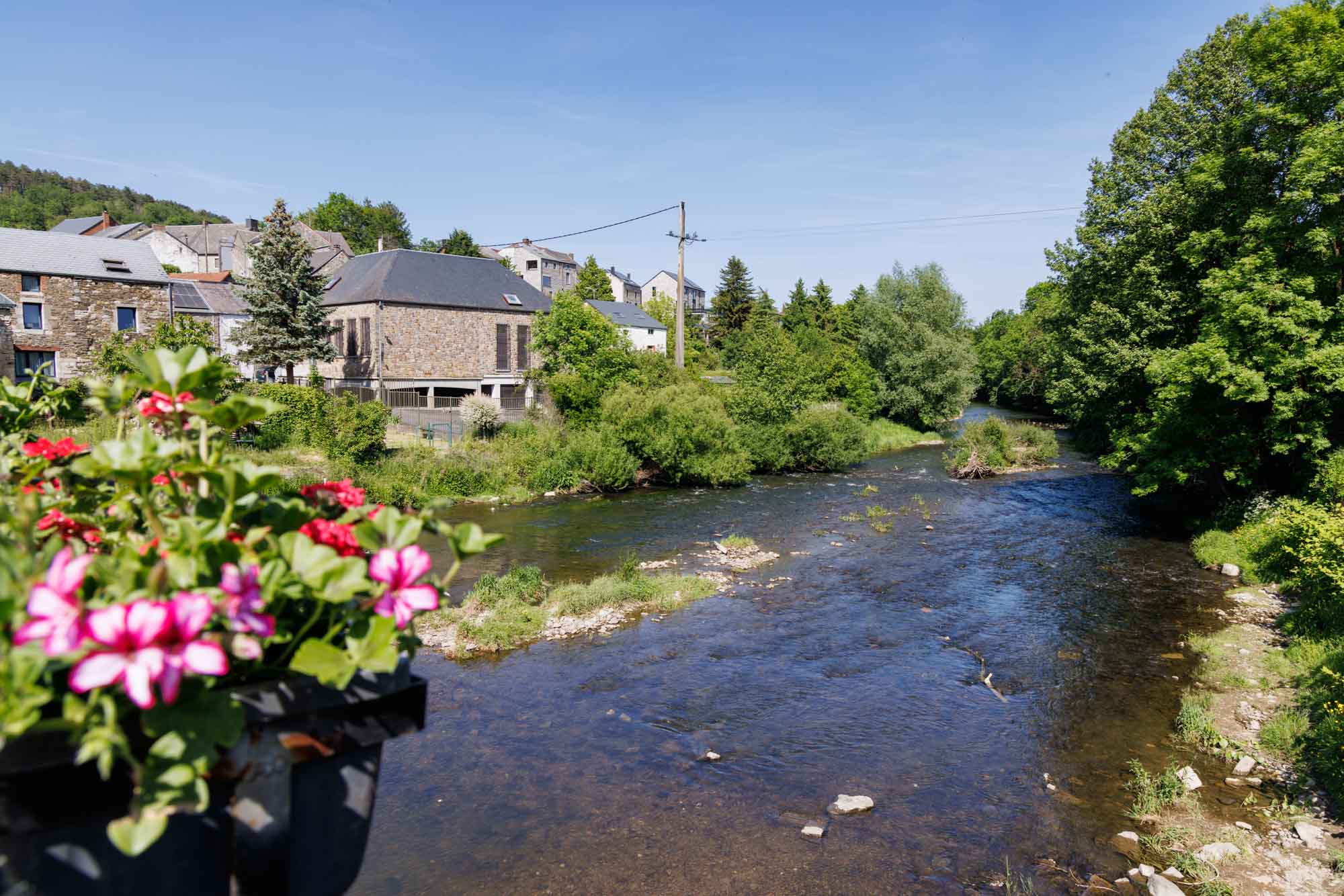 Rivier de Viroin met stenen huizen en groen in Vierves-sur-Viroin in de zomer.