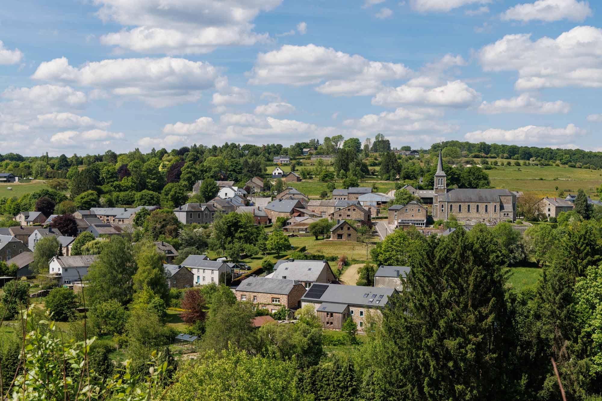 Panorama van Gembes met stenen huizen en kerk op de hoogten